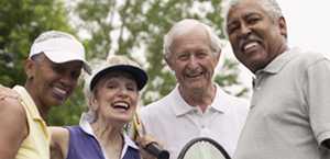 Photo: Four middle aged smiling tennis players 