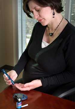 Pregnant woman testing for blood sugar levels