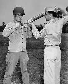 A US soldier is demonstrating DDT hand-spraying equipment. DDT was used to control the spread of typhus-carrying lice.