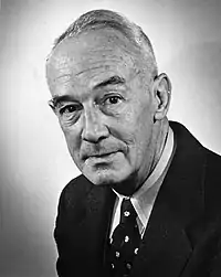 A black-and-white photographic portrait of a middle-aged man wearing a suit