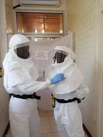 Liberian laboratory technicians in personal protective equipment preparing to test Lassa fever samples.
