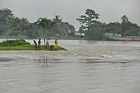 People on an island in a flooded river in Bangladesh