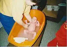 mother bathing an infant