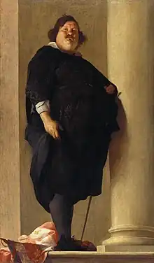 A very obese gentleman with a prominent double chin and mustache dressed in black with a sword at his left side.