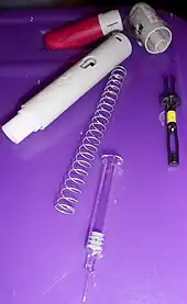 Components of a Humira autoinjector pen.