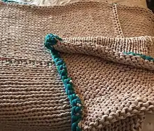 DIY knitted weighted blanket in pink and teal.