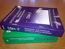 photo of the DSM-5 and DSM-IV-TR stacked on top of each other