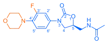 Skeletal formula of N-{[(5S)-3-[3-fluoro-4-(morpholin-4-yl)phenyl]-2-oxo-1,3-oxazolidin-5-yl]methyl}acetamide, highlighting the morpholino and fluoro groups in orange, with the rest in blue. The carbon atoms of the parent chain are numbered.
