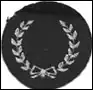 A small round black cloth badge with two white laurels curving around the edge of the circle, crossed at the bottom of the badge.