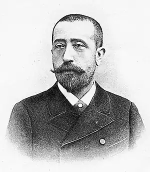 Head and shoulders of a man with a shorter Edwardian beard and closely cropped hair, in a circa-1870 French coat and collar