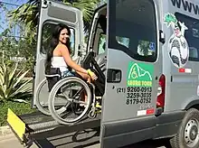 A special lift raises a wheelchair and its occupant in a bus