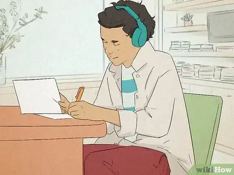 Image titled Man with headphones on working on his assignment.