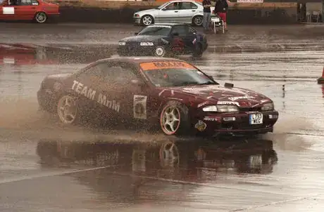 Image titled Shot at a shutter speed of 1/800. Notice that the wheels are stationary; the only indication that anything is moving in this shot is the spray coming from the wheels. Beautiful car, but boring photograph!