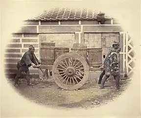Shariki pushing a cart loaded with barrels in pre-Meiji Japan