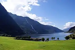 A fjord with steep sides and a waterfall on the left