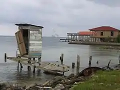 The outhouse over the water stands on the bay.