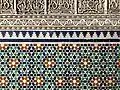 A detail of traditional Moroccan architectural elements: zeliij and arabesque plaster.