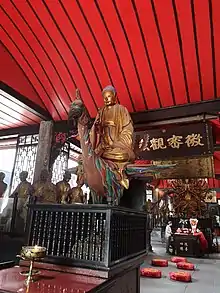 Statue of Mahāmāyūrī at the centre and the Thousand-armed Guanyin at the rear of the Five Hundred Arhat Hall of Baoguang Temple in Chengdu, Sichuan province, China