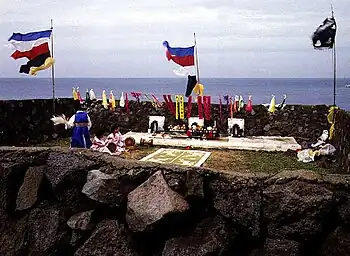 An outdoor shaman ritual, with several flags and banners.