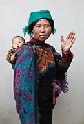 Yi woman in traditional dress with a child