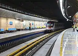 Top: Outside view of Imam Khomeini Metro StationBottom: A train at the Ghoddoosi Metro Station