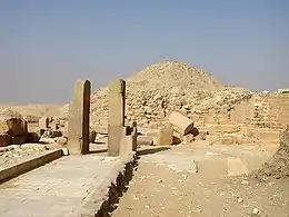 Photograph of a path, two vertical columns and main pyramid.