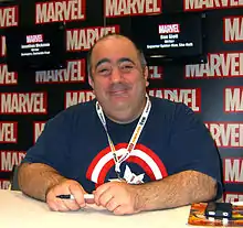 Slott seated at a table, smiling