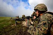 A soldier with the 17th Vânători de munte Battalion fires an M240B machine gun with a U.S. Marine of the Black Sea Rotational Force, during a live-fire exercise in the Carpathian Mountains, 2014