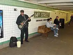 Musician playing on the southbound IND platform