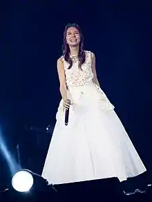 Japanese singer May J. dressed in white on stage performing