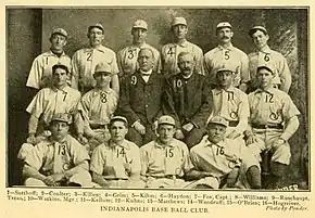 Fourteen men in light baseball uniforms and two in dark suits