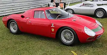 Low slung red road legal sports and racing car with closed cabin exhibited on grass in 2014