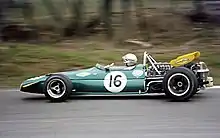 A mid-engined single-seater racing car with modest aerodynamic wings