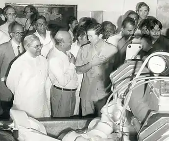 Black and white photograph of Charles in Gujarat with a crowd of people, 1980