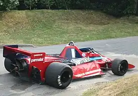 A mid-engined single-seater racing car with large aerodynamic wings and a big fan on the back