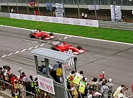 Photograph showing Rubens Barrichello making way to allow Michael Schumacher to cross the finish line ahead of him