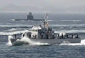 A Chamsuri-class patrol craft and a Sohn Wonyil-class submarine on background