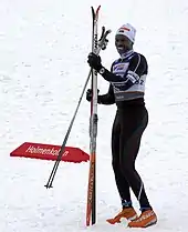 Colour photograph of Philip Boit holding skis