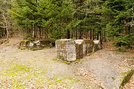 Deux blocs de béton avec chacun deux surfaces arrondies où reposaient les réservoirs.