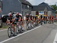 A group of cyclists riding single file.