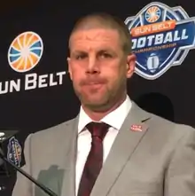 Billy Napier in a suit at a press conference.