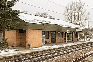 One-story brick building with slanted roof covered in snow