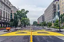 Looking down 16th Street with a large letter "B" in yellow paint and the beginnings of the letter "L" taking shape.