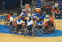 A wheelchair basketball team in a huddle