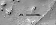 Possible dike in Thaumasia quadrangle, as seen by HiRISE under the HiWish program.  Dikes may have deposited valuable minerals.