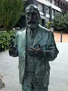 Life-sized statue of a man standing with his hands extended
