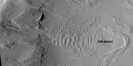Glacier on a crater floor, as seen by HiRISE under HiWish program  The cracks in the glacier may be crevasses.  There is also a gully system on the crater wall.  Location is Casius quadrangle.