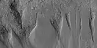 Close view of gullies from previous image  The channels are quite curved.  Because channels of gullies often form curves, it was thought that they were made by flowing water.  Today, it is thought that they could be produced with chunks of dry ice.  The image is from HiRISE under HiWish program.