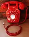 1970 741L Reproduction wall mounted telephone in red.  These telephones were only issued to fire services and originally had no dial.