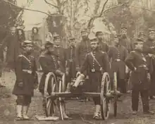 Sepia-toned photo shows several Union soldiers of the 96th Pennsylvania Infantry posing next to a small caliber cannon.